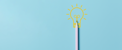 A pastel pink pencil standing upright on a light blue background, with a glowing yellow lightbulb illustration above it, symbolizing creativity, inspiration, and the writing process.